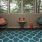 a living room with a blue rug and a table with chairs